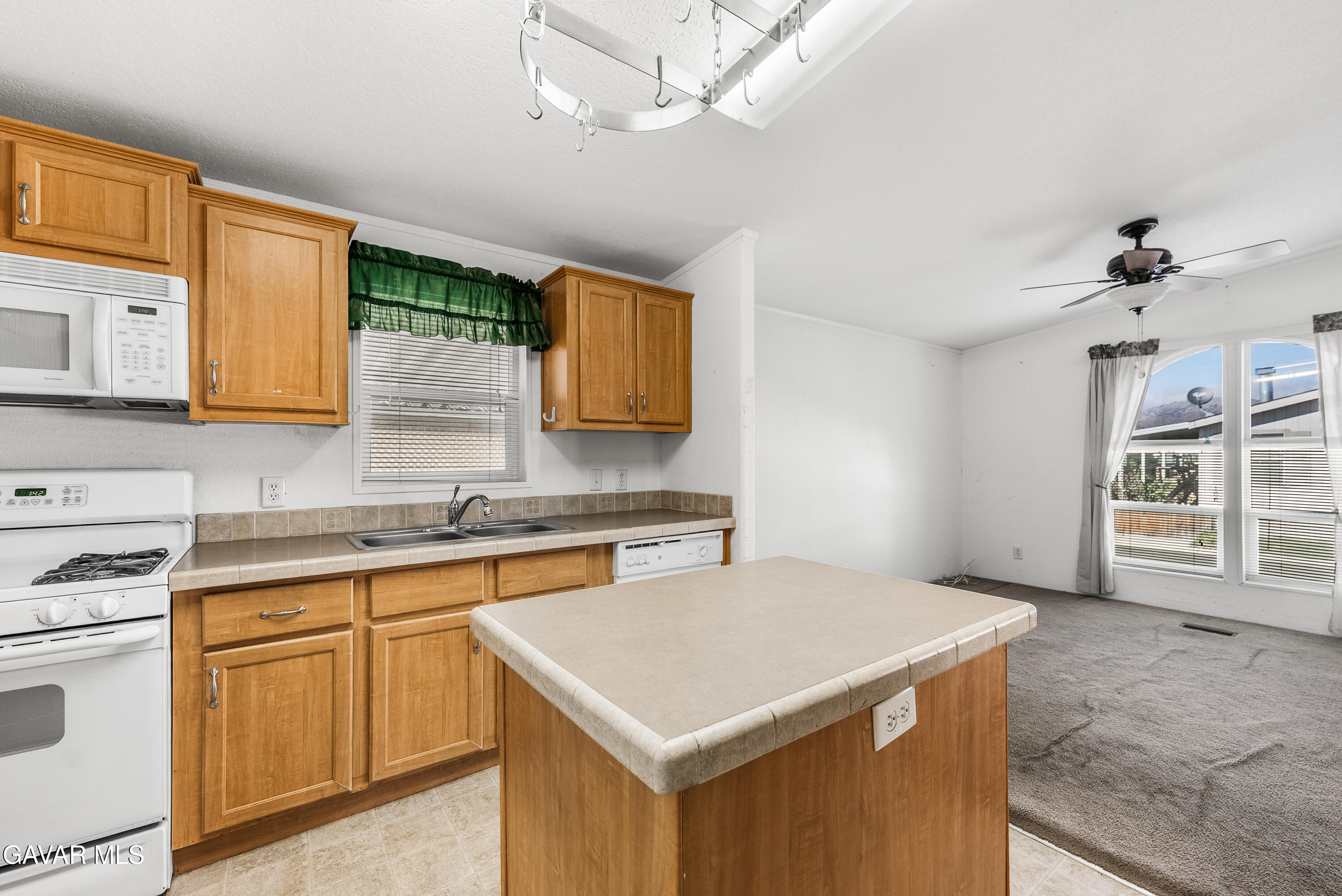 600 Dennison Road Tehachapi, CA 93561 - Photo 15 of 43 a kitchen with a stove a sink a microwave and cabinets