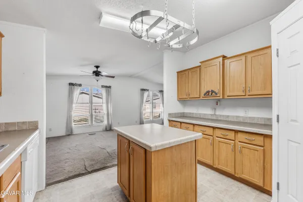 a kitchen with cabinets a chandelier and stainless steel appliances