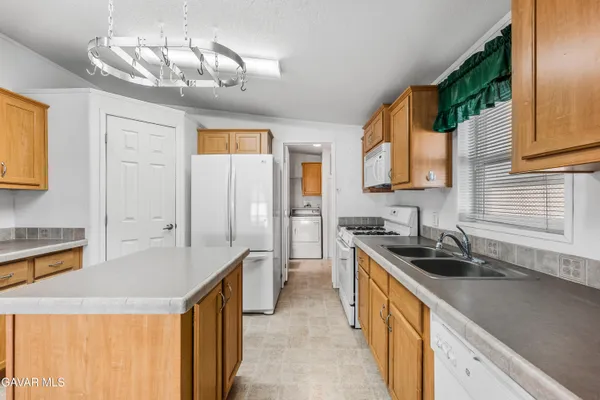 a kitchen with stainless steel appliances granite countertop a sink a stove and a refrigerator