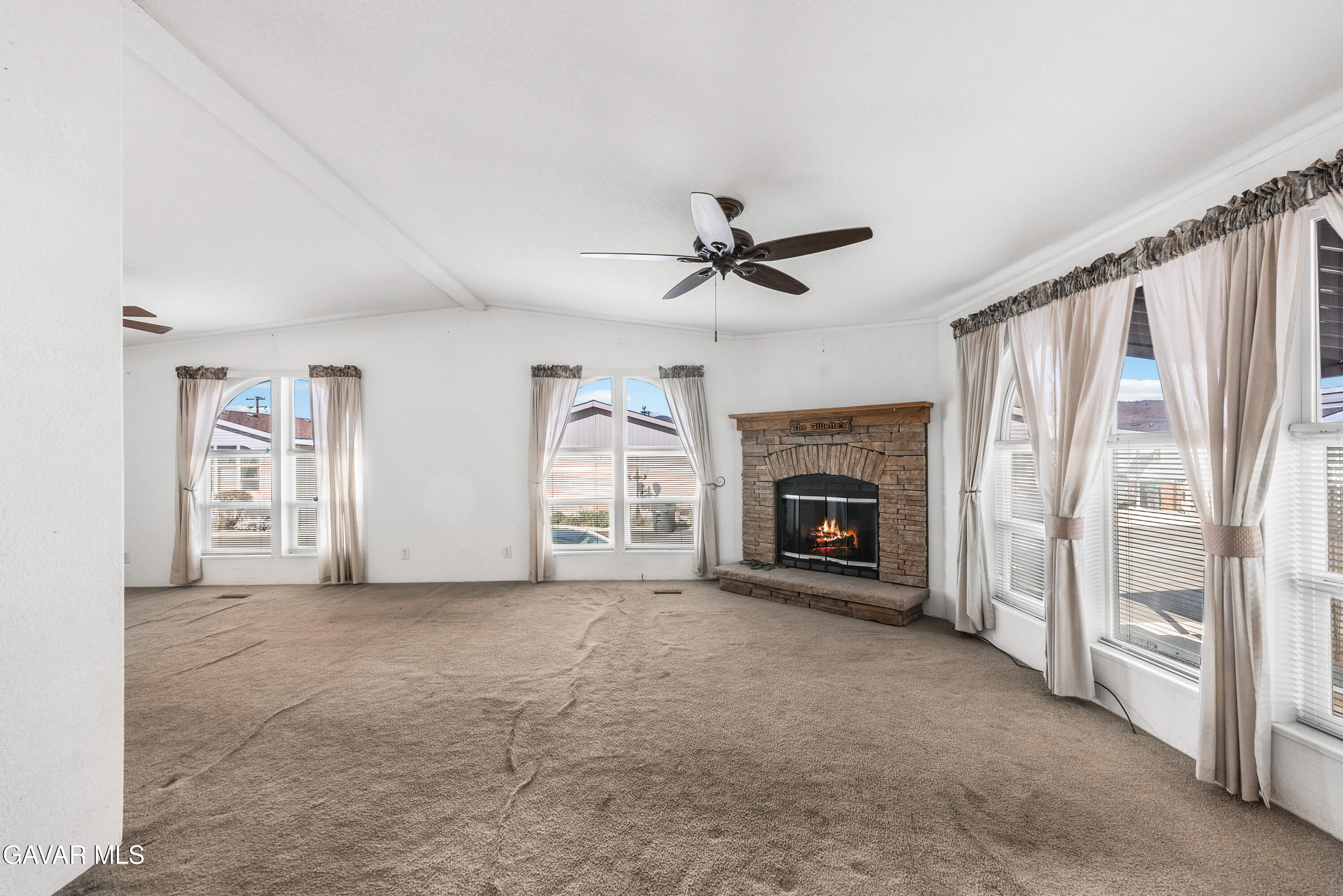 600 Dennison Road Tehachapi, CA 93561 - Photo 5 of 43 a view of a livingroom with a fireplace a ceiling fan a fireplace and windows
