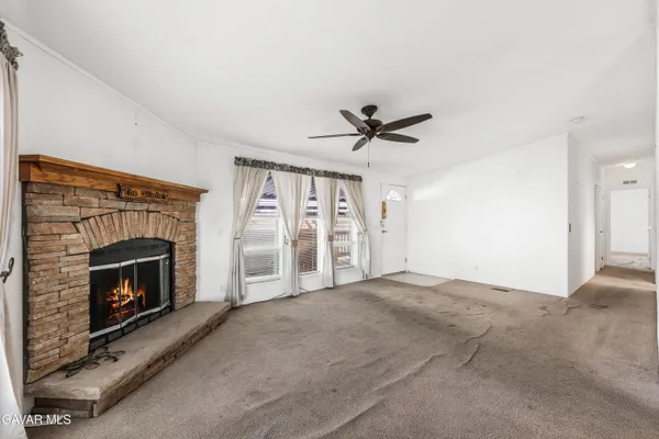 a view of empty room with fireplace and fan