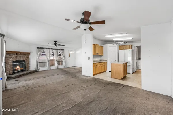 a view of a kitchen with a sink a refrigerator and a fireplace