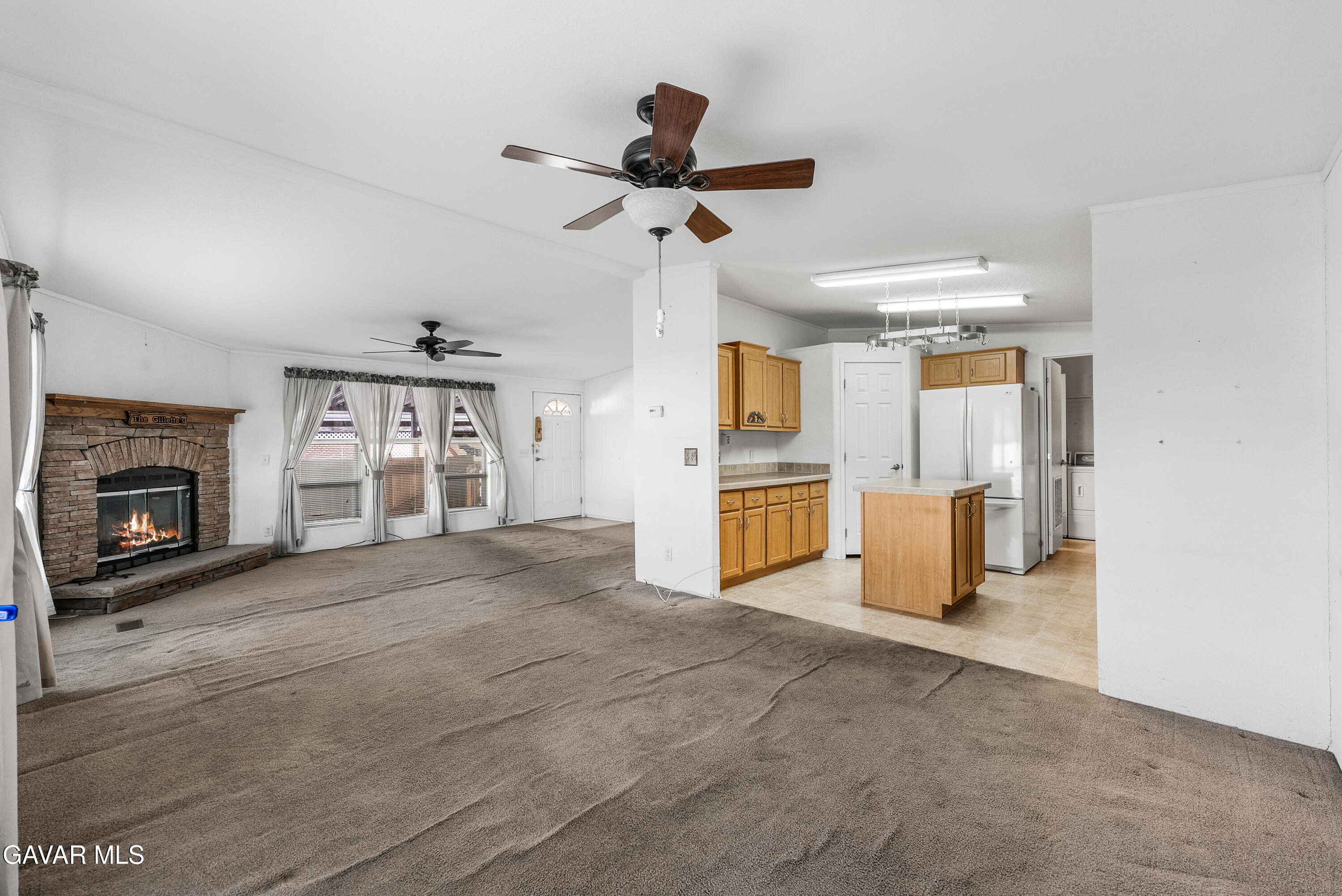 600 Dennison Road Tehachapi, CA 93561 - Photo 10 of 43 a view of a kitchen with a sink a refrigerator and a fireplace
