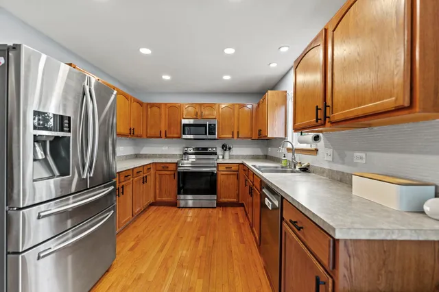a kitchen with stainless steel appliances granite countertop wooden cabinets sink and a granite counter top