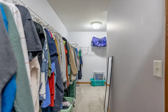a view of a hallway with closet and a closet
