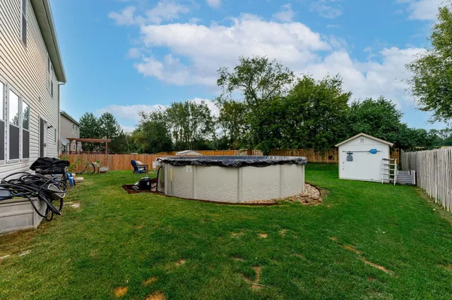 a front view of a house with a garden and chairs