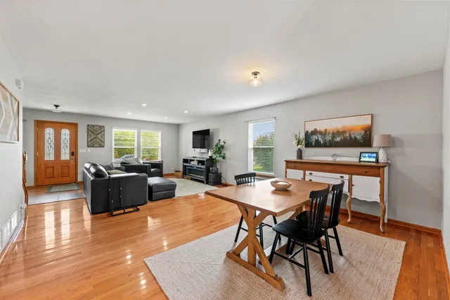 a living room with furniture a table and wooden floor