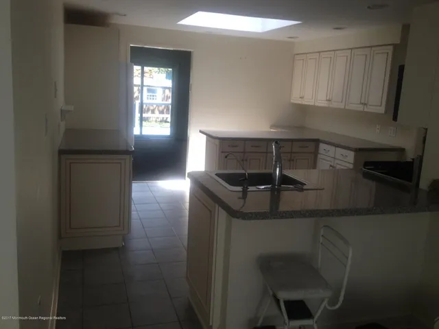 a kitchen with granite countertop a sink and cabinets