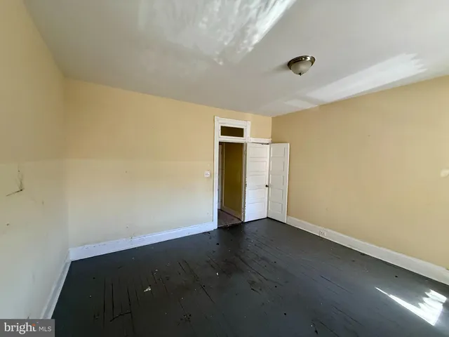 an empty room with wooden floor and closet