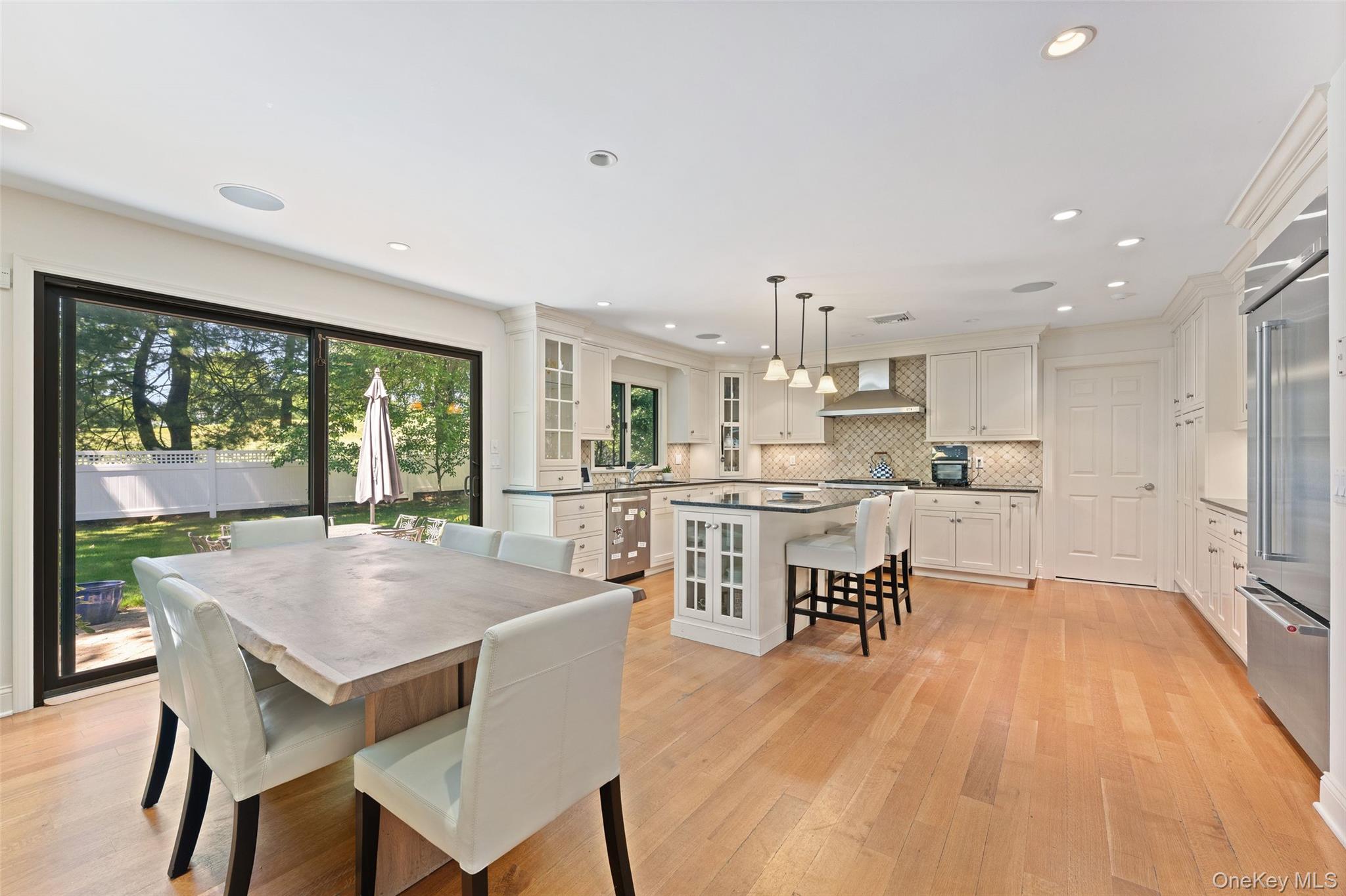 6 Magnetti Circle Mamaroneck, NY 10543 - Photo 5 of 24 a open kitchen with a table chairs refrigerator and cabinets