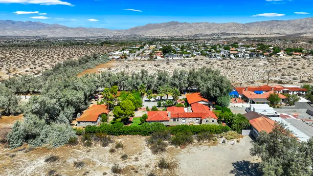 an aerial view of residential houses with outdoor space and trees