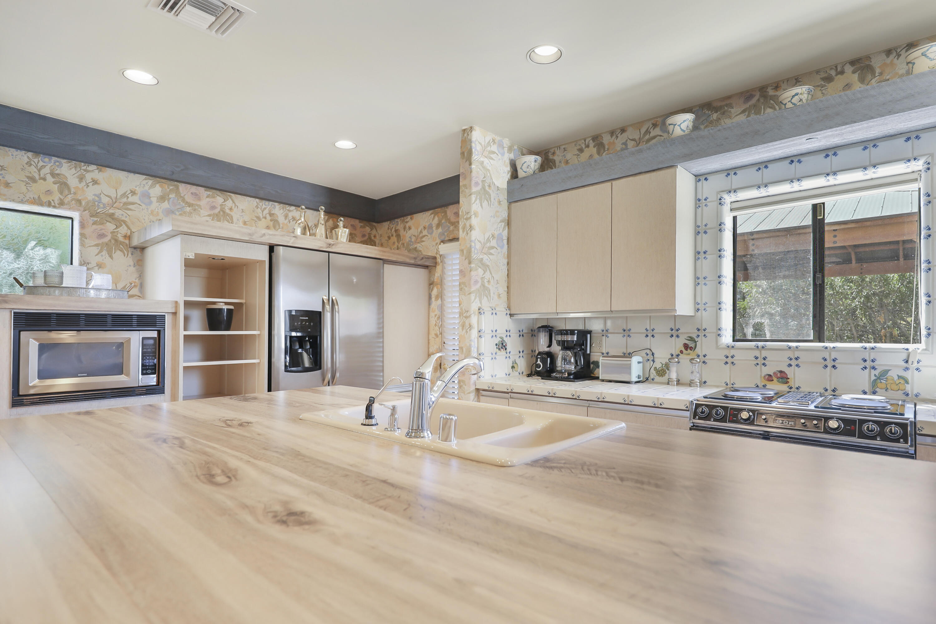 19120 Bubbling Wells Road Desert Hot Springs, CA 92241 - Photo 11 of 45 a swimming pool with kitchen view and a large window