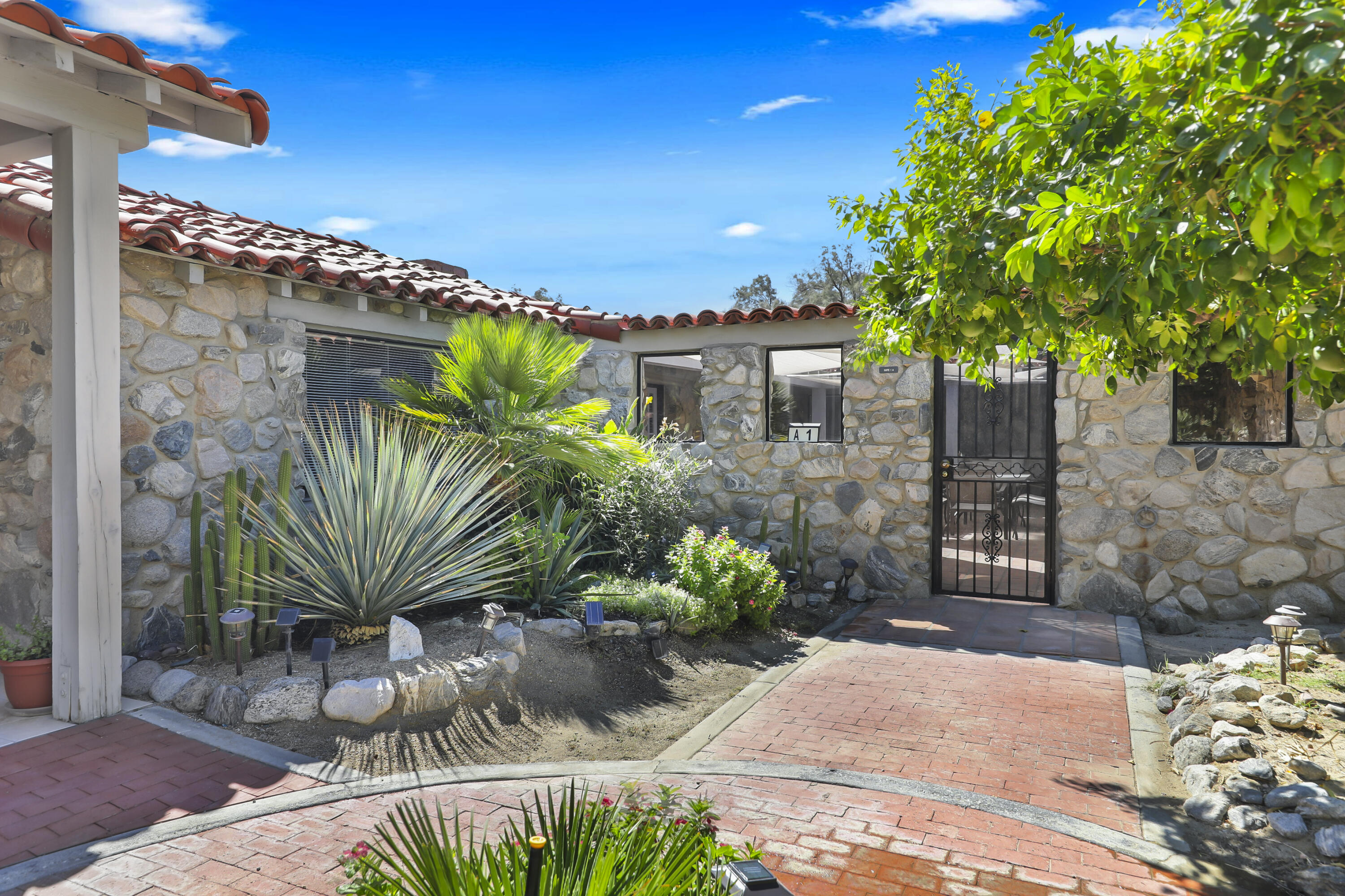 19120 Bubbling Wells Road Desert Hot Springs, CA 92241 - Photo 2 of 45 a front view of a house with a garden
