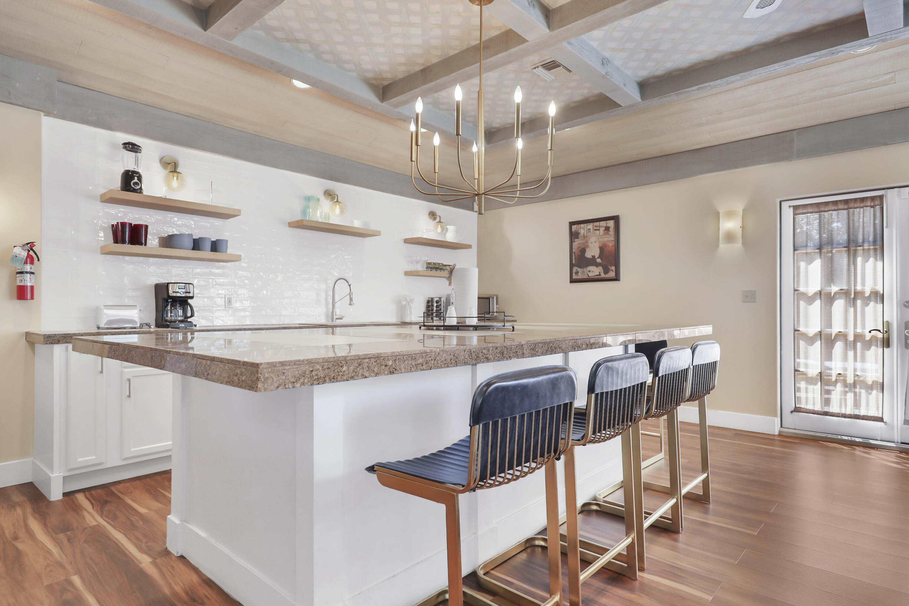 19120 Bubbling Wells Road Desert Hot Springs, CA 92241 - Photo 21 of 45 a kitchen with stainless steel appliances granite countertop a stove top oven a dining table and chairs with wooden floor