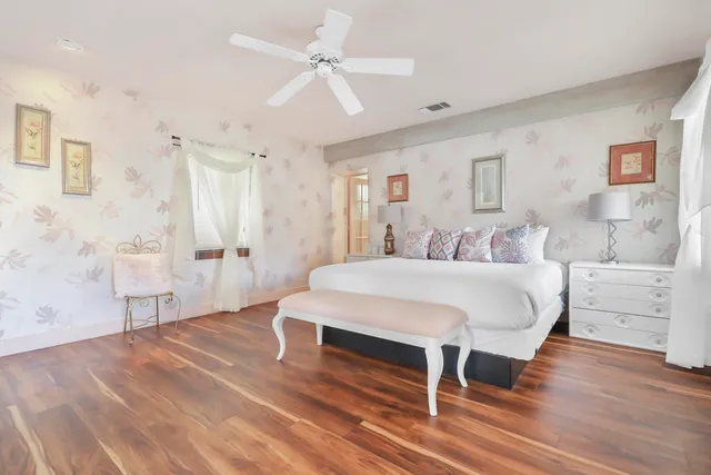 a spacious bedroom with a bed and a chandelier