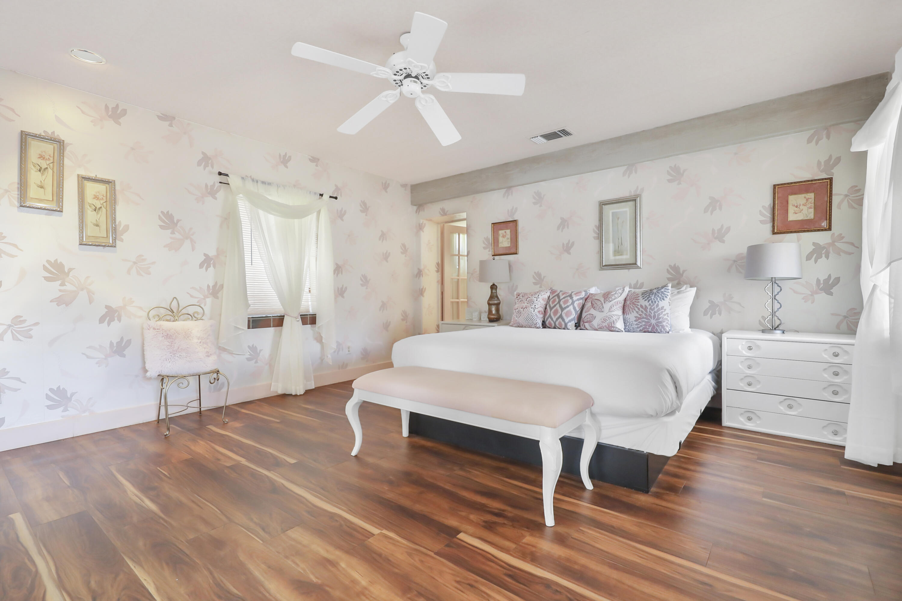 19120 Bubbling Wells Road Desert Hot Springs, CA 92241 - Photo 23 of 45 a spacious bedroom with a bed and a chandelier