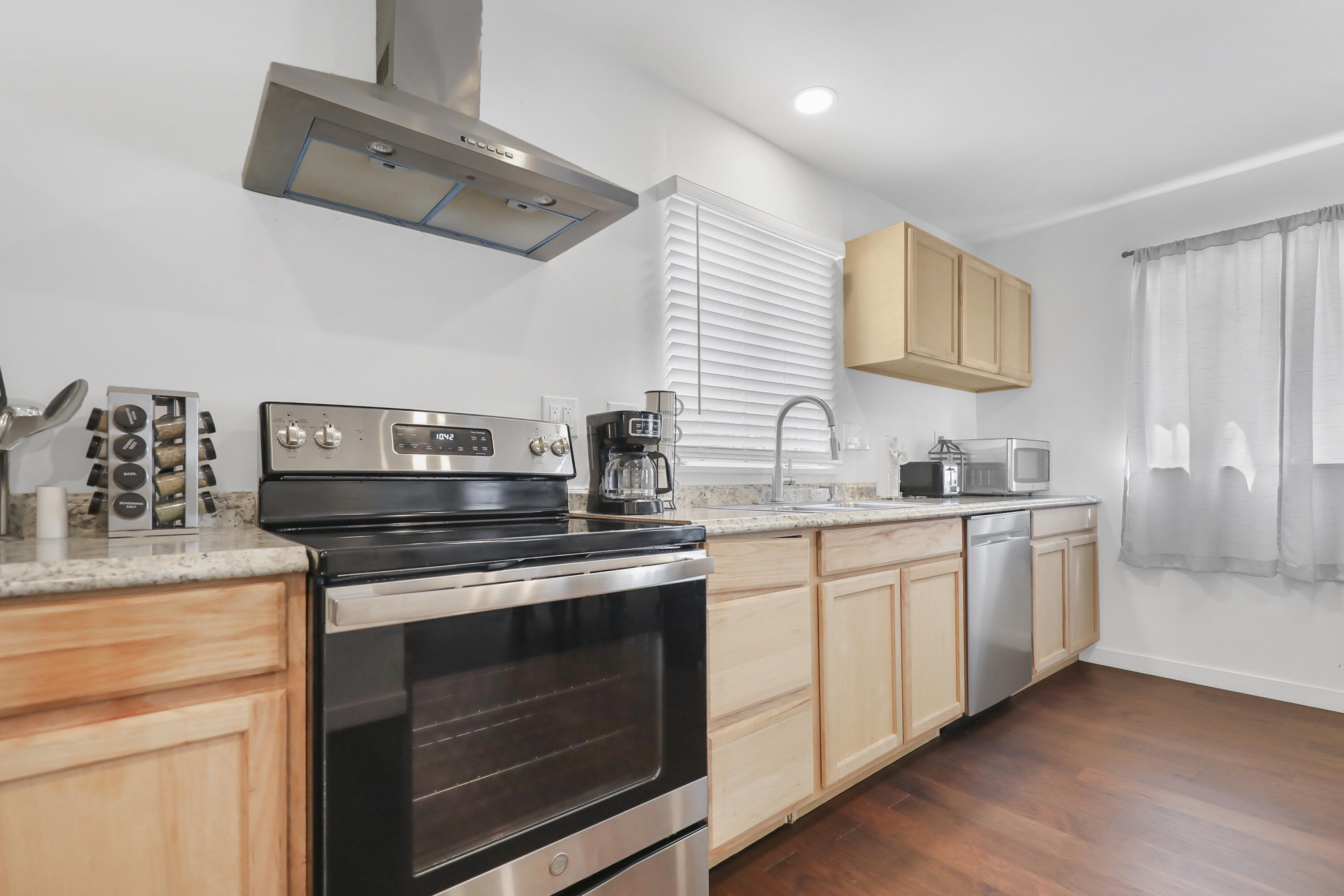 19120 Bubbling Wells Road Desert Hot Springs, CA 92241 - Photo 29 of 45 a kitchen with stainless steel appliances a stove microwave and sink