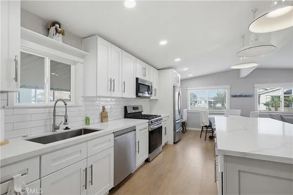 a large kitchen with kitchen island a sink stainless steel appliances and cabinets