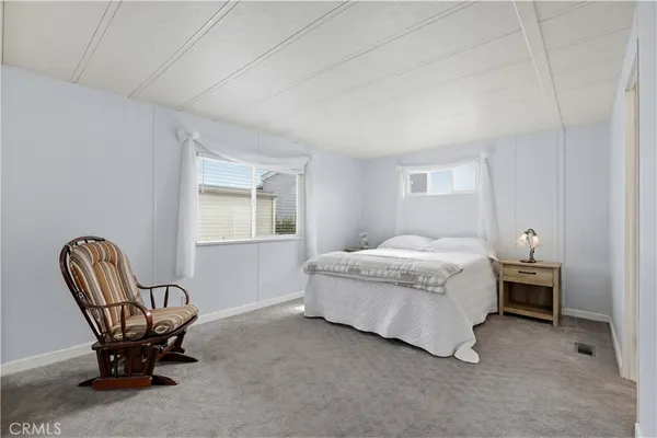 a bedroom with a bed and a large window