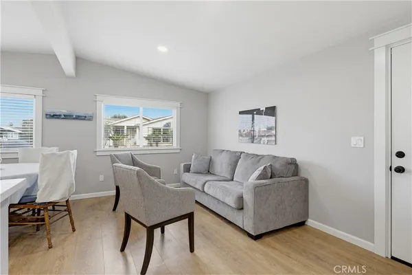 a living room with furniture and a view of kitchen