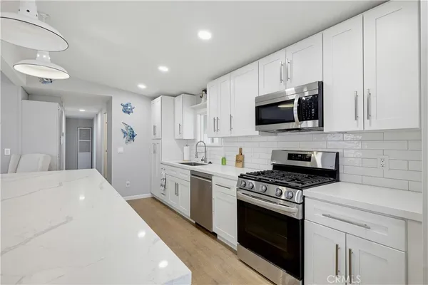 a kitchen with stainless steel appliances a stove microwave and sink