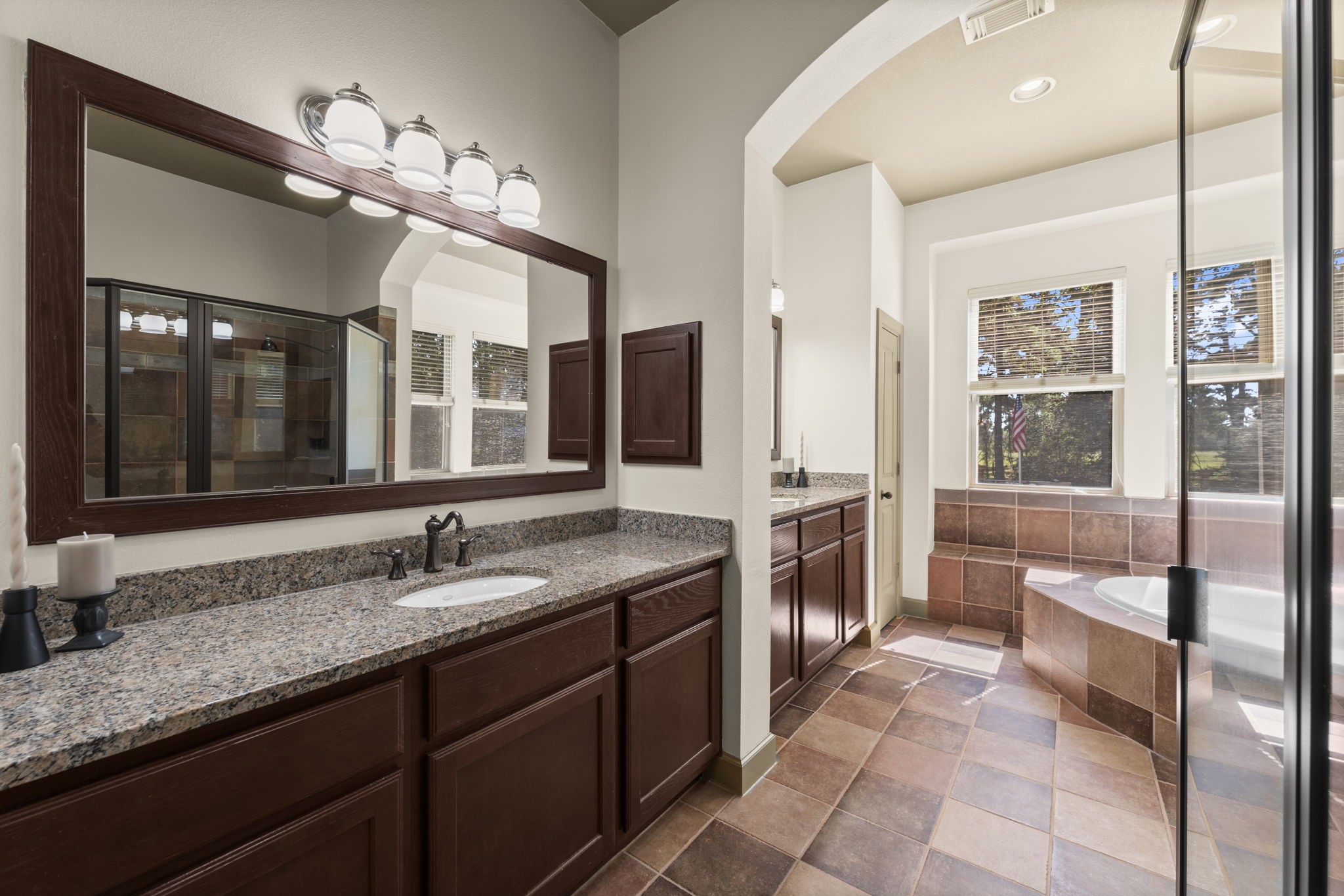 1534 Virgie Community Road Magnolia, TX 77354 - Photo 29 of 50 The primary bathroom boasts ample counter space, a luxurious soaking tub, and a standalone shower, creating a perfect blend of functionality and relaxation.
