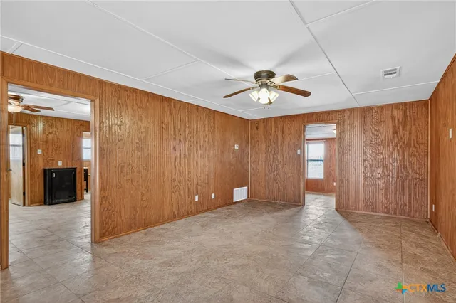 an empty room with fan and windows