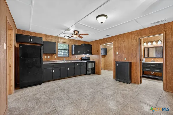 a large kitchen with a stove and a refrigerator