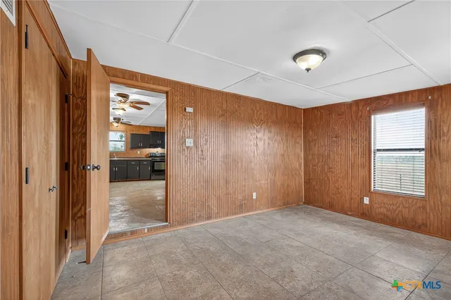 an empty room with kitchen and windows