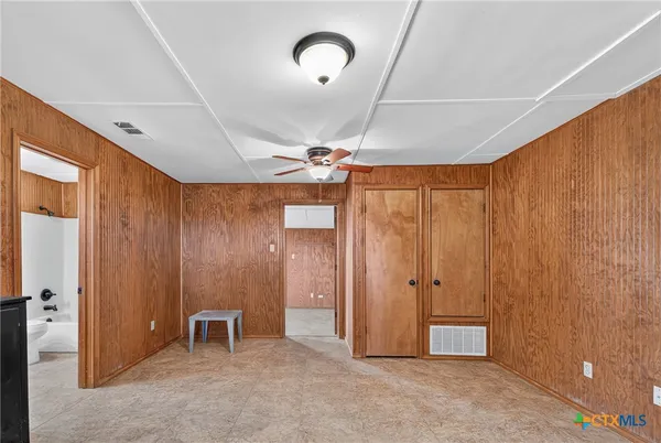 an empty room with closet and windows