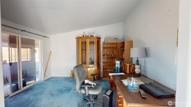 a view of a workspace with furniture and a window