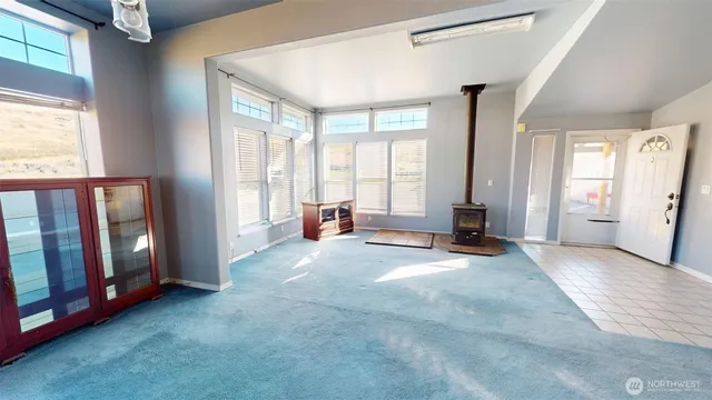 a view of an empty room with window and a livingroom with furniture