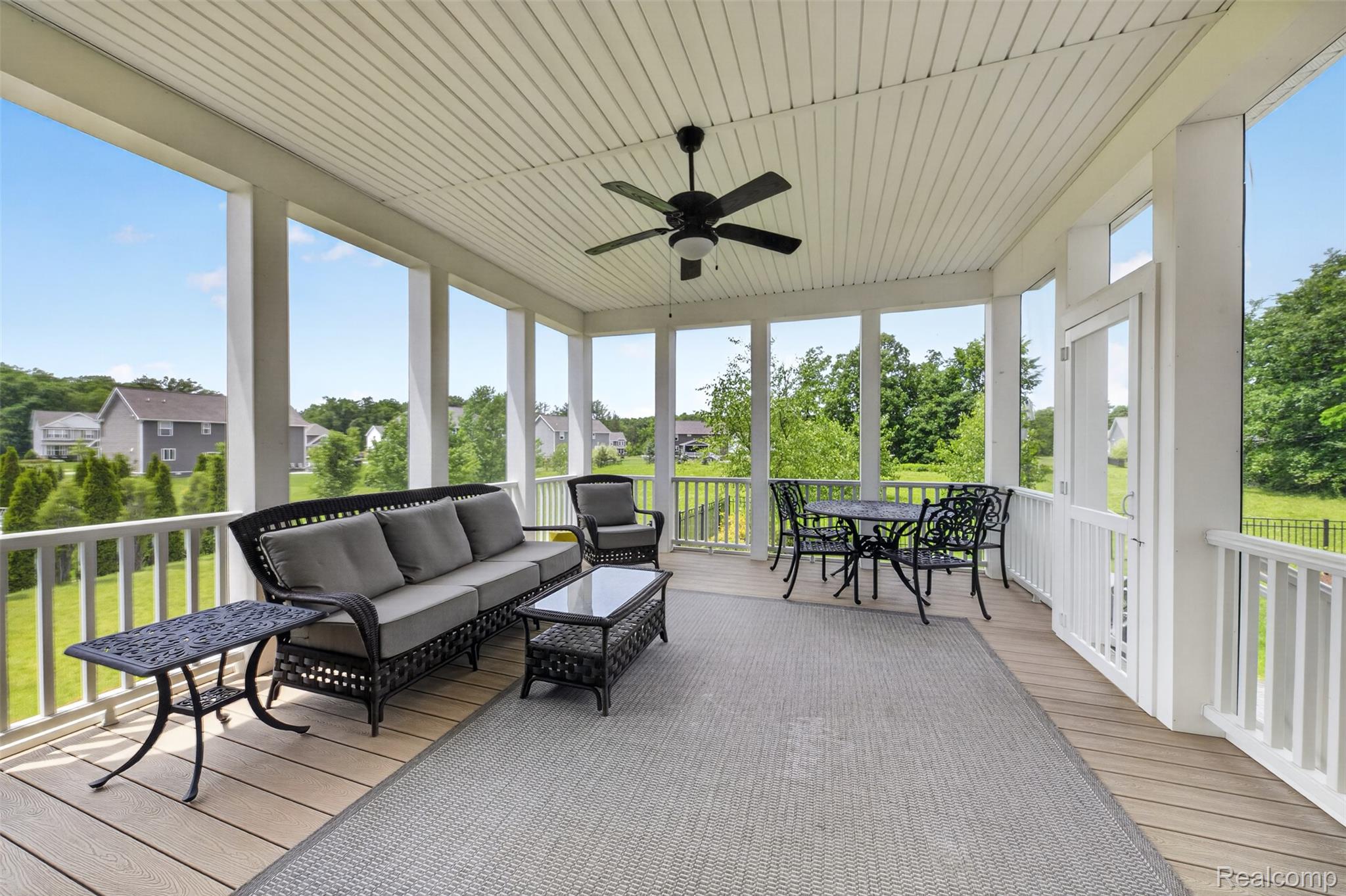 2531 Walnut View Drive Howell, MI 48855 - Photo 30 of 34 Spacious screened porch featuring a ceiling fan, light wood-finish decking, white railings, a painted beadboard ceiling, and clear views of the surrounding landscape