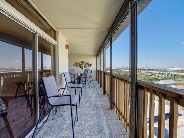 a view of a balcony with chairs and wooden floor