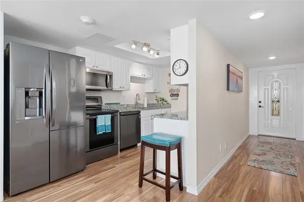 a kitchen with kitchen island a counter top space stainless steel appliances and cabinets