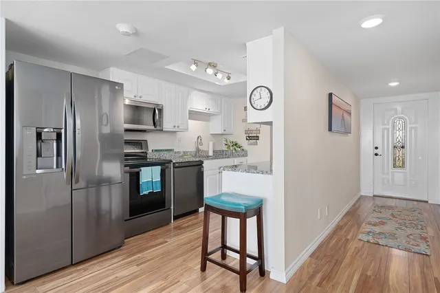 a kitchen with stainless steel appliances kitchen island granite countertop a stove a sink and a refrigerator