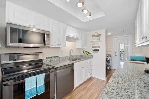 a kitchen with stainless steel appliances kitchen island granite countertop a stove a sink and a refrigerator