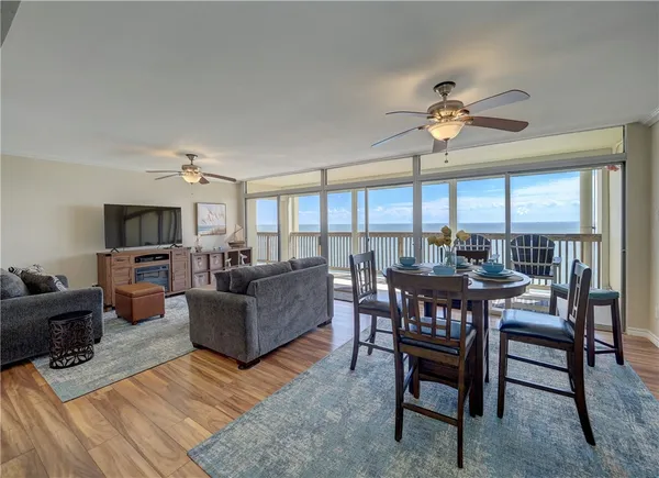 a living room with furniture a flat screen tv and a large window