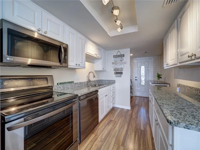 a kitchen with stainless steel appliances granite countertop a stove microwave and cabinets