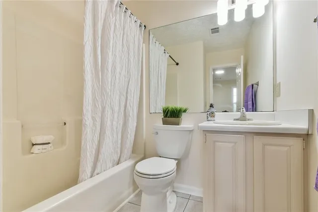 a bathroom with a sink a toilet and shower curtain