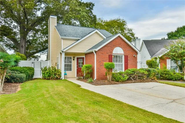 a front view of a house with a yard and potted plants