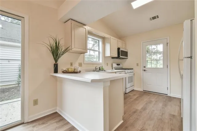a kitchen with a sink a window and cabinets