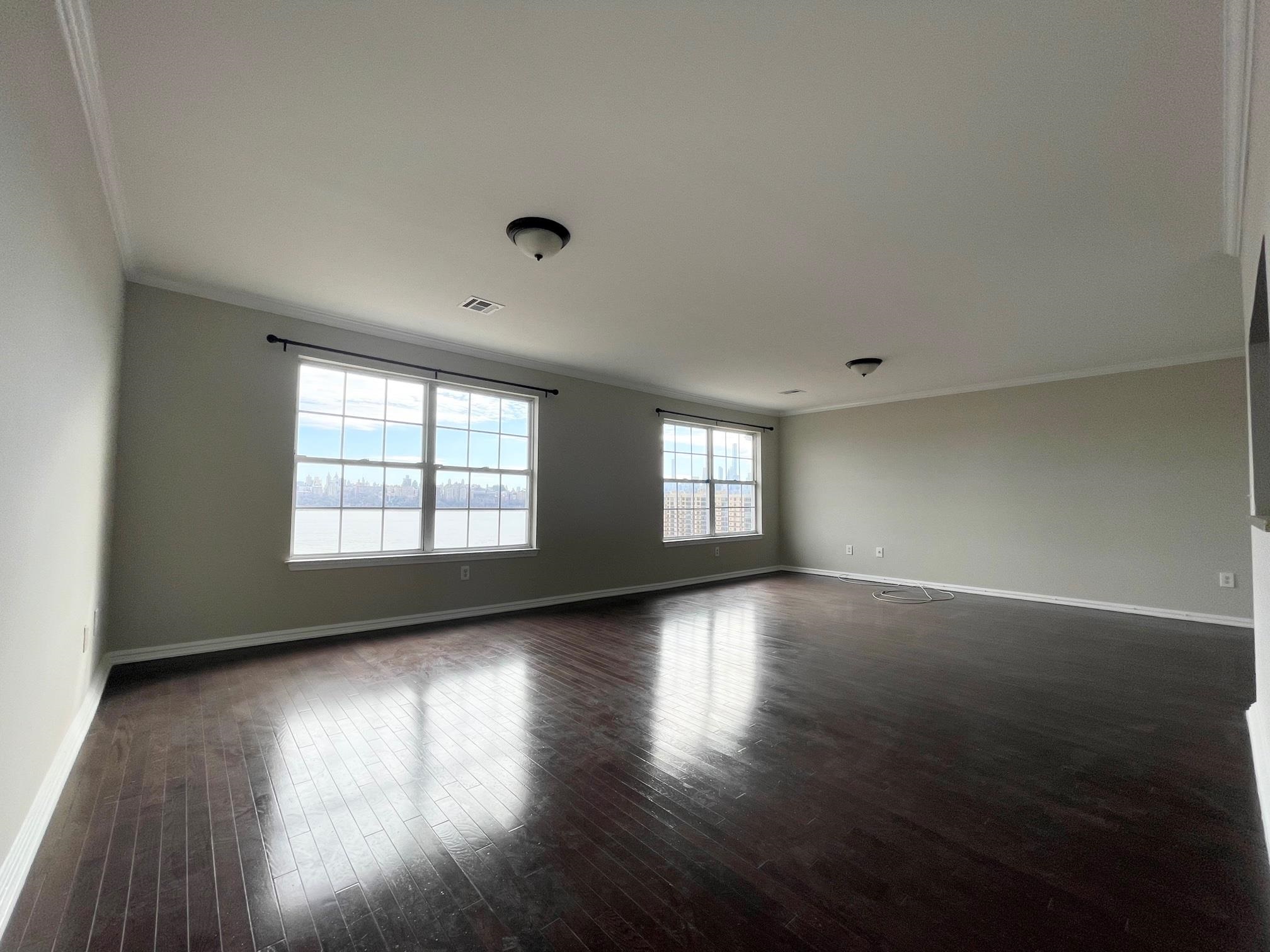 26 Bergen Ridge Road, Unit 2 North Bergen, NJ 07047 - Photo 2 of 9 an empty room with wooden floor and windows