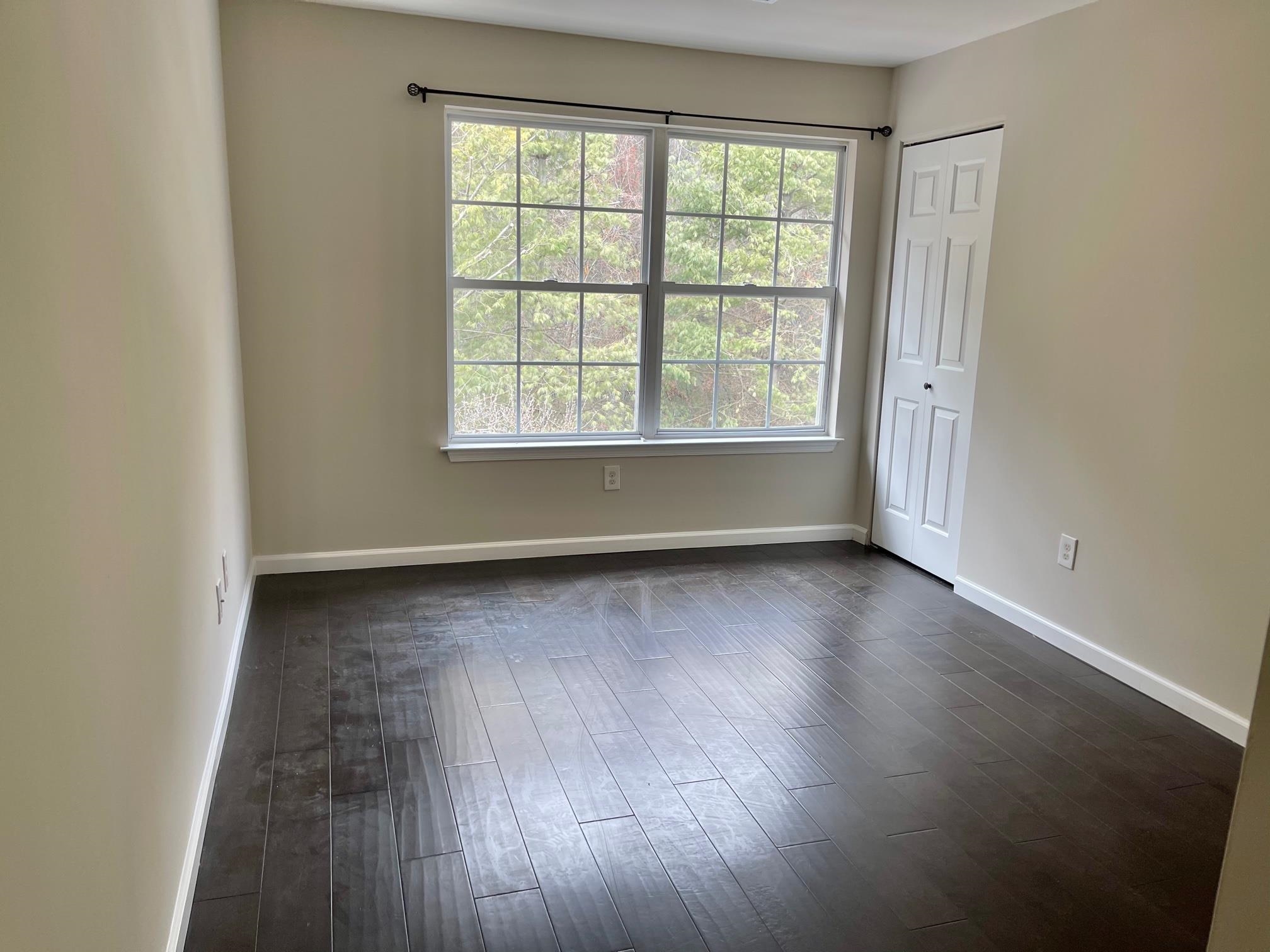 26 Bergen Ridge Road, Unit 2 North Bergen, NJ 07047 - Photo 4 of 9 an empty room with wooden floor and windows