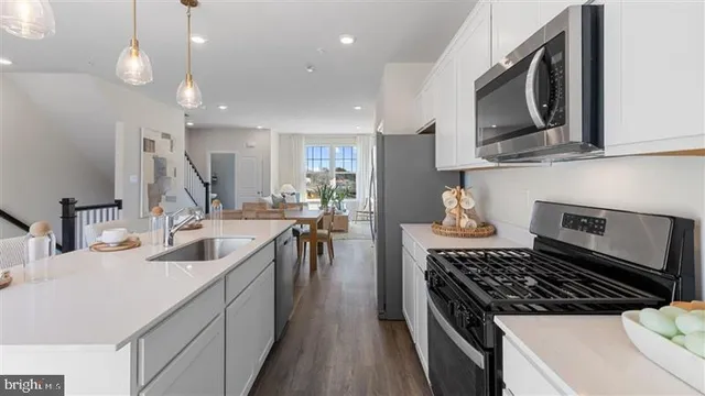 a kitchen with kitchen island granite countertop a sink a stove oven and cabinets