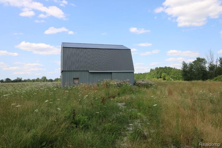 6577 East Deckerville Road Deford, MI 48729 - Photo 5 of 16 Pole barn structure with a metal roof, vertical siding, and a sliding door