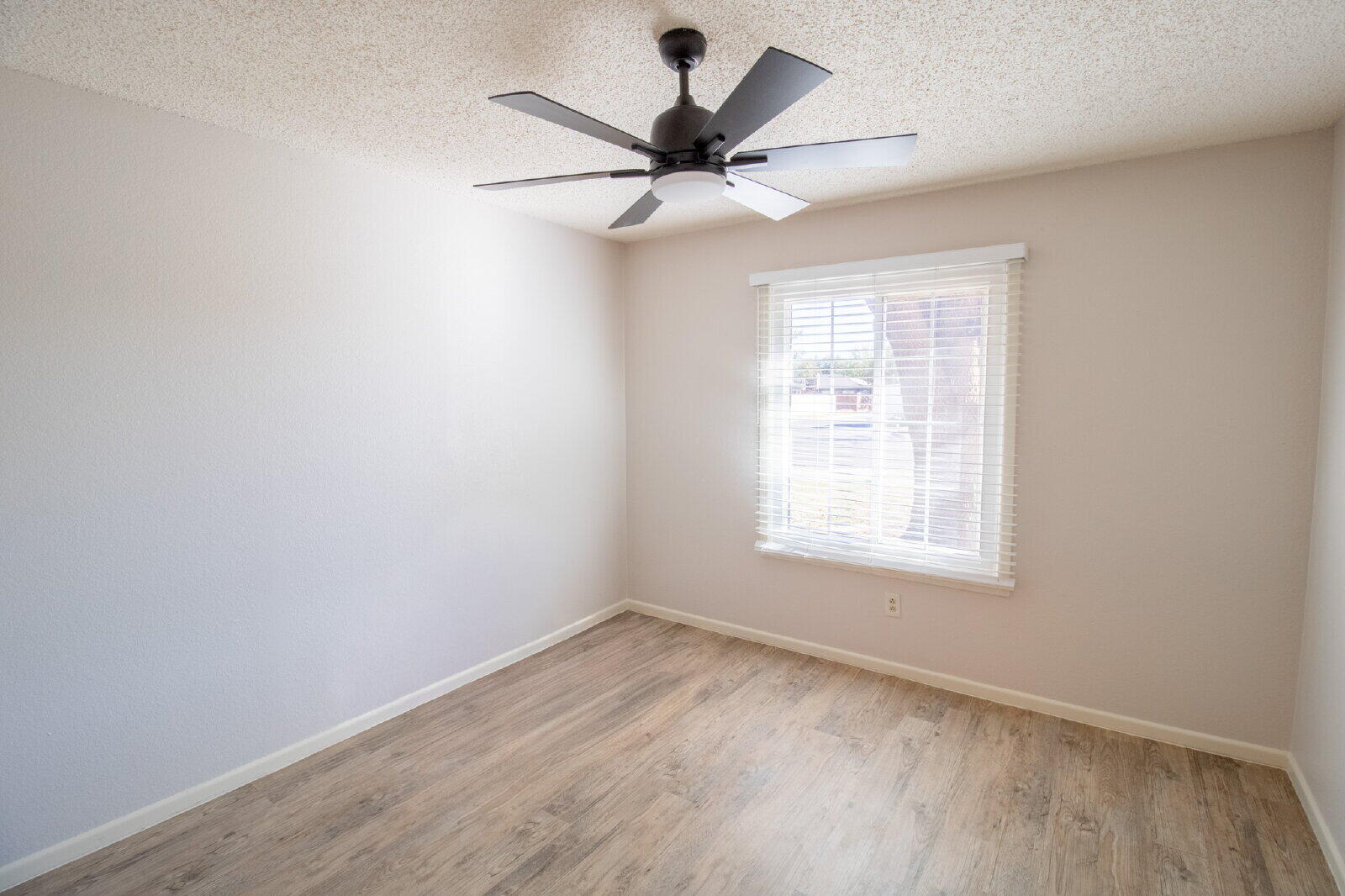5718 90th Street Lubbock, TX 79424 - Photo 12 of 15 an empty room with wooden floor fan and windows