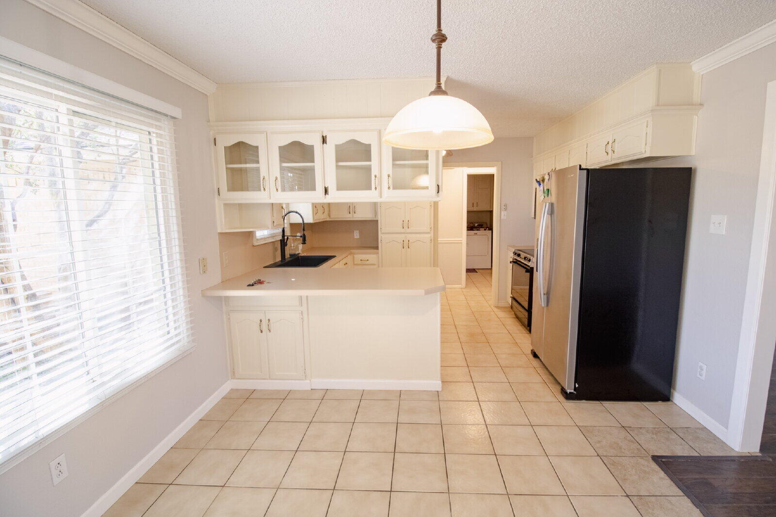 5718 90th Street Lubbock, TX 79424 - Photo 3 of 15 a kitchen with stainless steel appliances a refrigerator and a stove top oven