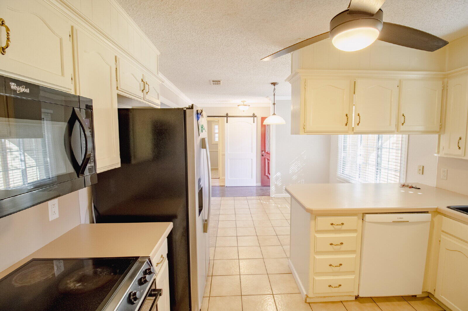 5718 90th Street Lubbock, TX 79424 - Photo 6 of 15 a kitchen with a refrigerator and a sink