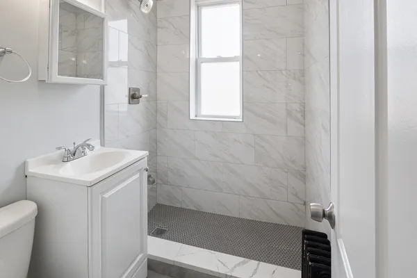 a bathroom with a sink a toilet and shower